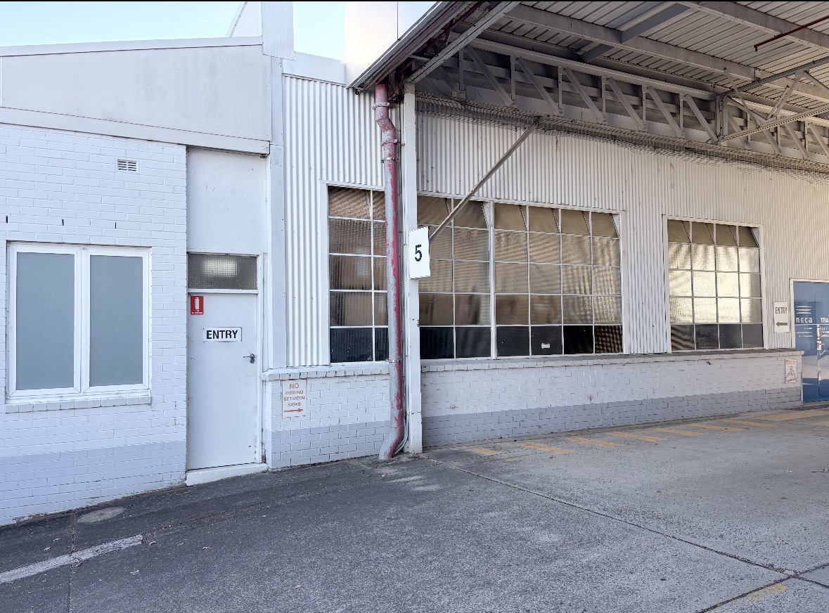 Rear depot and covered loading bay with multi-pane factory windows