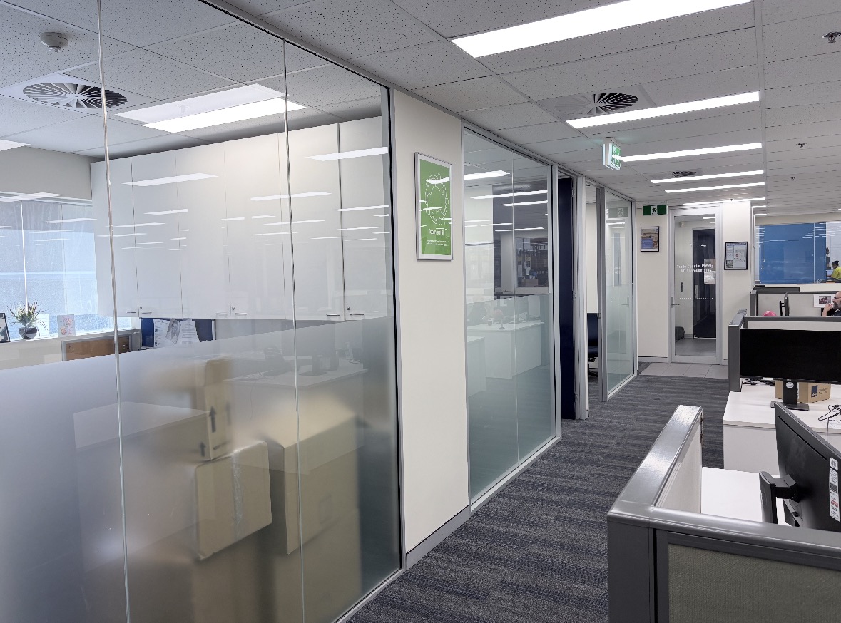 Office floor with full-height glass partitions and meeting-room glass